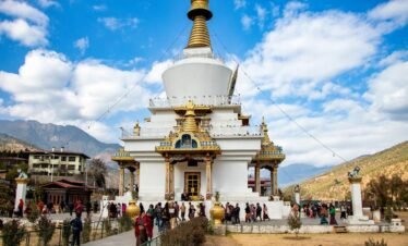 A vibrant view of Memorial Chorten, a religious landmark in Thimphu, Bhutan, surrounded by visitors.
