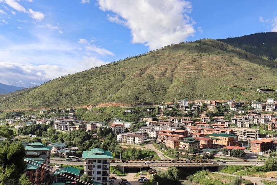 A picturesque view of a mountain town featuring a bridge and residential buildings.