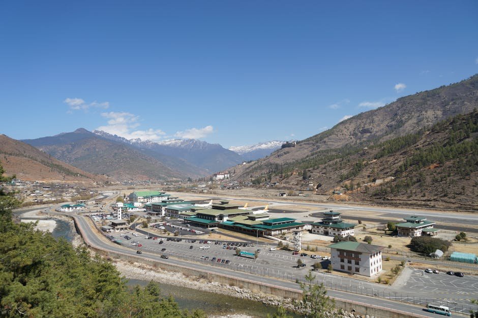 Aerial view of Paro Airport surrounded by mountains, showcasing Bhutan's stunning landscapes and unique architecture.