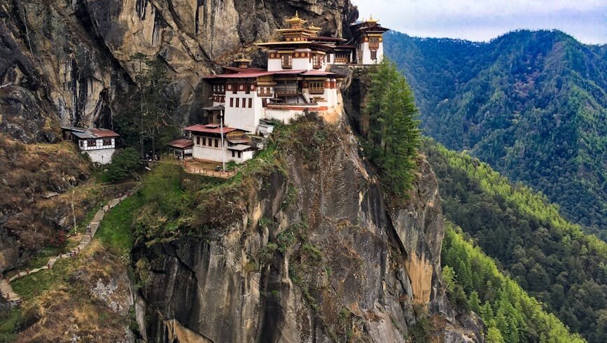 A breathtaking view of the iconic Tiger's Nest Monastery perched on a cliff in Bhutan's lush landscape.